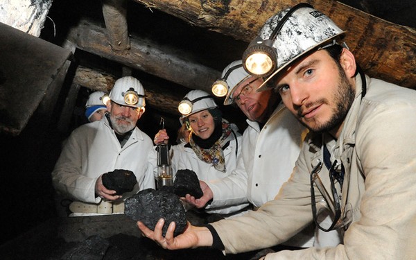 Besucher in weißem Schutzanzug und Helmim Nachtigallstollen.