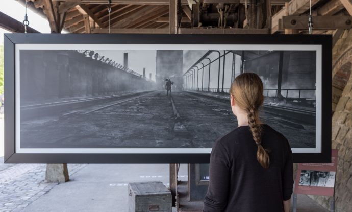 Besucherin vor einem Ausstellungsbild im Außenbereich Besucherin vor einem Ausstellungsbild im Außenbereich