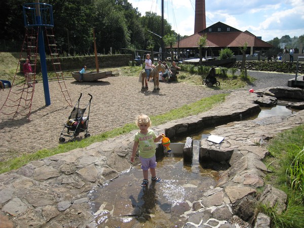 Mädchen spielt am Bachlauf auf dem Wasserspielplatz der Zeche Nachtigall.