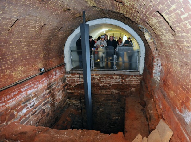 Menschen blicken in den freigelegten Schacht Herkulues unter dem Gewölbe des Ringofens.