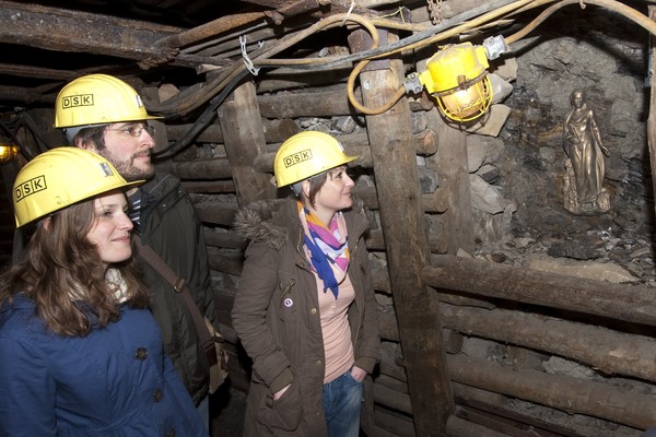 Teilnehmer der Stollenfürhung im Stollen mit Grubenhelm.